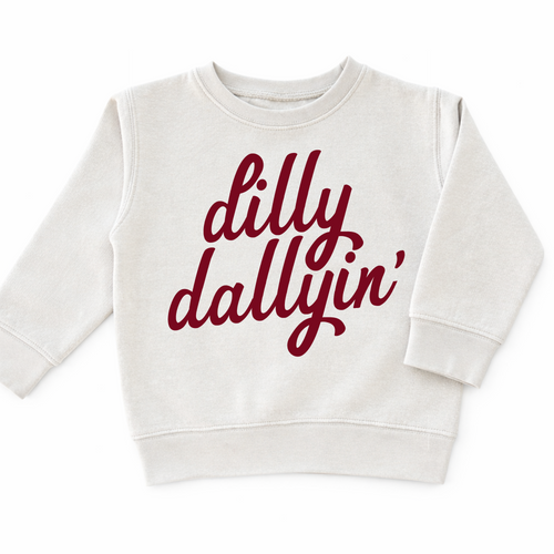 Cream toddler boys sweatshirt featuring red "Dilly Dallyin'" script graphic, trendy fall sweatshirt for boys and toddlers.